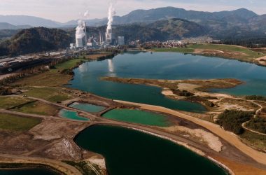 An aerial shot of a landscape surrounded by mountains and lakes with industrial disaster